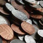 Close-up of various international coins in a pile, showcasing different currencies and designs.